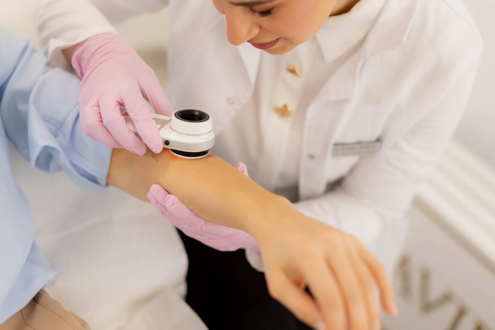 Dermatologist examining a patient's skin with a handheld device