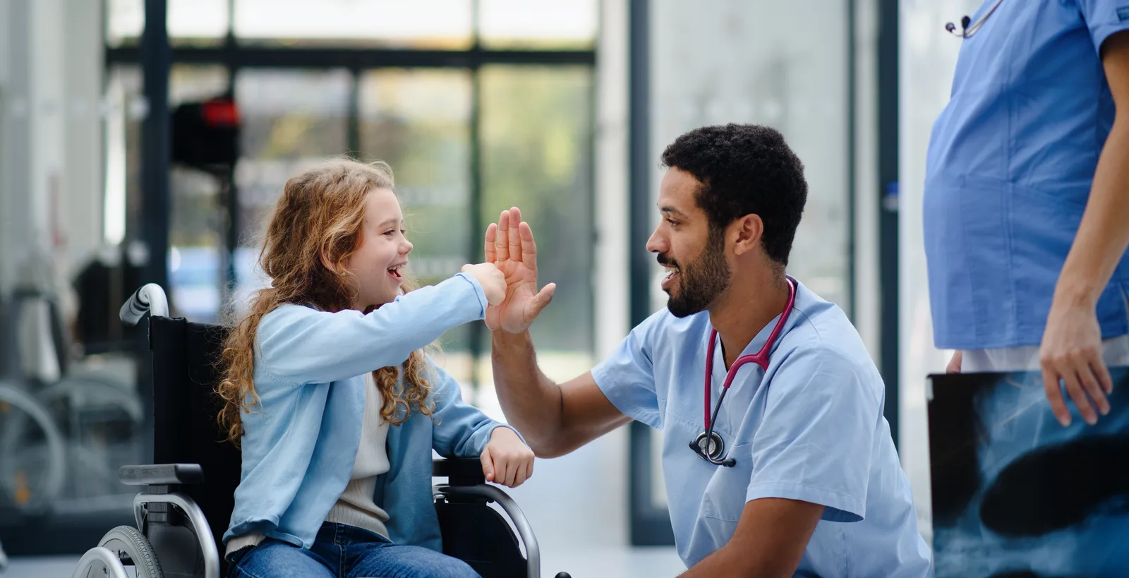 Pediatric clinician high-fiving a child in a clinic